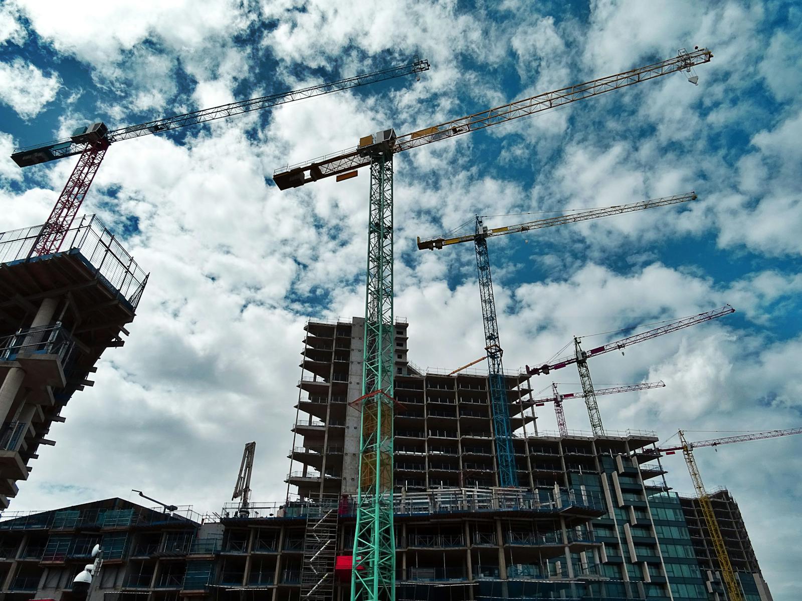 High-rise concrete frame and cranes during multi-level structural construction
